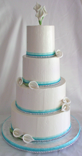 4 tier white buttercream wedding cake with mint green ribbons, bling/diamond ribbons and hand made sugar calla lilies