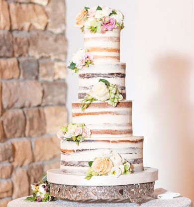 4 Tier semi naked wedding cake decorated with fresh flowers