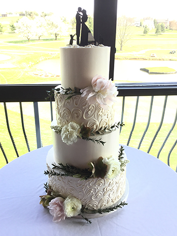 4 Tier buttercream wedding cake decorated with buttercream scrolls, fresh flowers and greenery, delivered to Heritage Hills, York PA