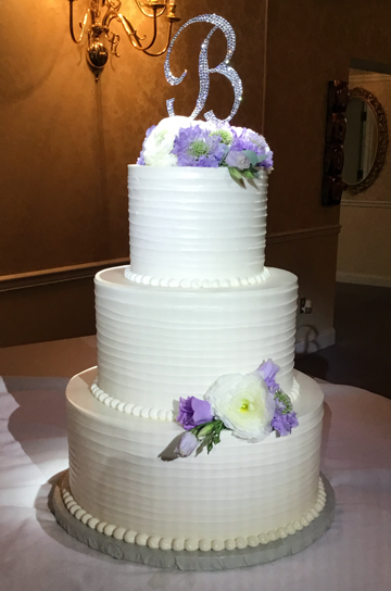 3 Tier simple and clean buttercream wedding cake with textured exterior decorated with fresh flowers delivered to Wisehave Event Center in York PA