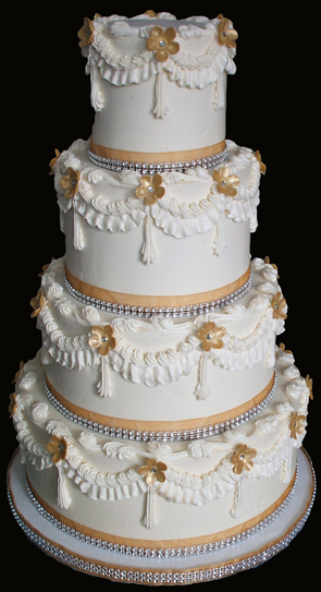 4 tier buttercream wedding cake decorated with gold and diamond bling ribbons and heavy buttercream scallops