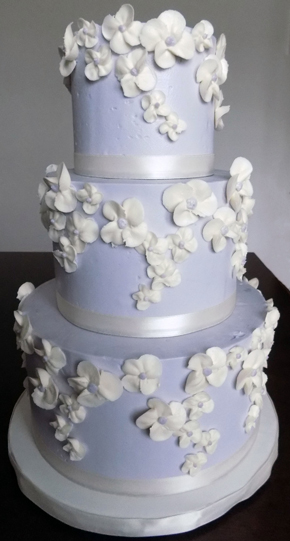 3 Tier buttercream wedding cake, iced in lilac buttercream and decorated with ivory buttercream blossoms