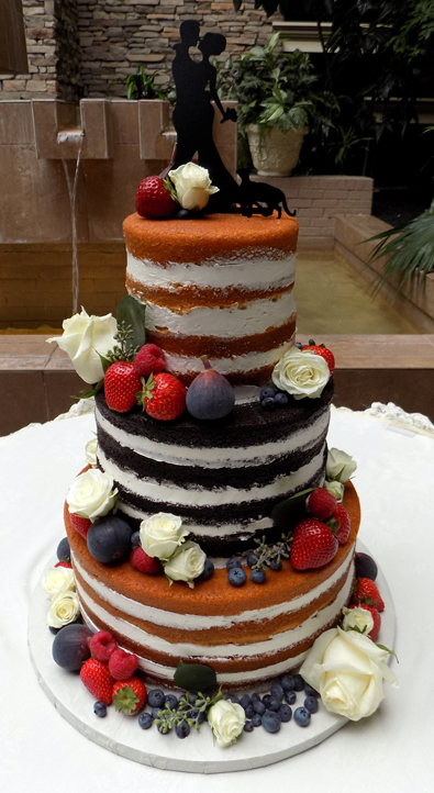 3 Tier truly naked wedding cake decorated with fresh fruit and flowers. Wedding Cakes Eden Resort Lancaster PA
