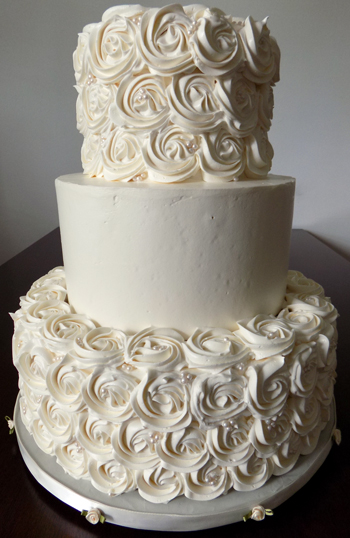 3 Tier buttercream wedding cake decorated with buttercream rosettes and sugar pearls. Wedding Cakes York PA