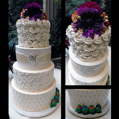 4 Tier buttercream wedding cake decorated with rosettes, scrolls, quilt deisgn, fondant sash and monogram, fondant pearls, gold sugar dragees/pearls and Ninja turtles for the groom. Wedding Cakes Lancaster PA