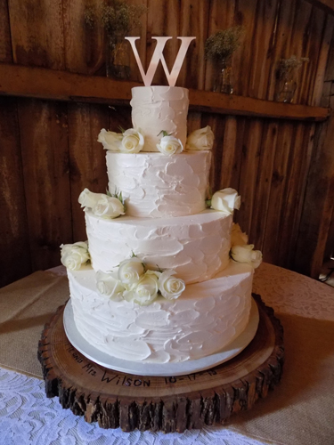 4 Tier rustic textured buttercream wedding cake, decorated with fresh white roses. Wedding cake was delivered at the Pine Ridge Farm in Stewartstown PA.