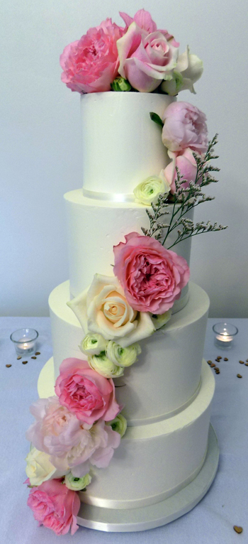 Four tier buttercream wedding cake decorated with an assortment of fresh flowers including roses, peonies and ranunculus - wedding cakes Yoe PA